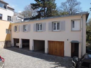 une grande maison blanche avec un garage dans l'établissement Alleehaus, à Fribourg-en-Brisgau