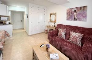 a living room with a red couch and a table at Estudios Costavigía Mazagón by Ramona in Mazagón