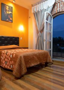 ein Schlafzimmer mit einem Bett und einem großen Fenster in der Unterkunft Hotel Jatziri in San Juan Teotihuacán