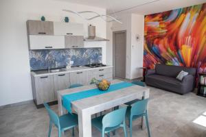 uma cozinha com mesa e cadeiras e um quadro em Appartamento Profumo di Mare em Marina di Ragusa