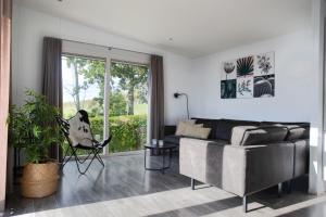 a living room with a couch and a large window at Vakantiepark de Molenhoek in Kamperland
