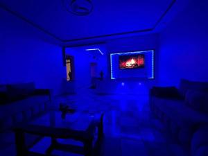 a blue living room with a couch and a tv at IDGA appartement with panoramic view in Chefchaouen