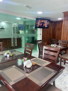 a dining room with a table and chairs and a television at Hotel El Mirador in Ciudad Valles