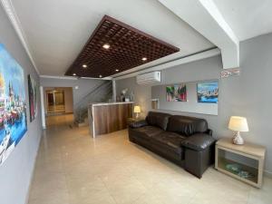 a living room with a leather couch and a table at Hotel Amoek in Cartagena de Indias