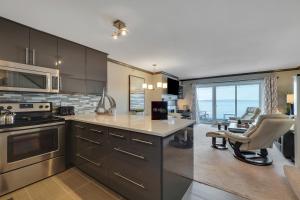 a kitchen with stainless steel appliances and a living room at 311 Water Street Inn in Boyne City