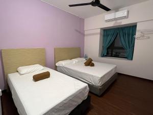 Cette chambre comprend deux lits et une fenêtre avec des rideaux bleus. dans l'établissement BayView Villas Condo - Premium Unit, à Port Dickson