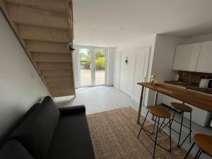 a living room with a couch and a table and a kitchen at La belle de Nuits in Nuits-Saint-Georges