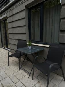 Dos sillas y una mesa en un patio. en Golden Garden Luxury Apartment in Bucharest, en Bucarest