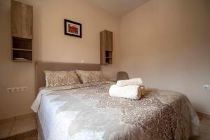 1 dormitorio con 1 cama con edredón blanco en Casa Greca Vacation Home Acharavi Corfu en Acharavi