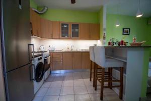 cocina con paredes verdes, fregadero y encimera en Casa Greca Vacation Home Acharavi Corfu en Acharavi