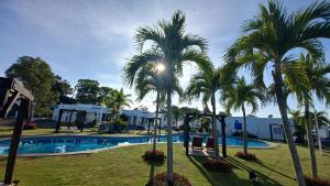 un parco giochi con palme accanto a una piscina di ADVENTURE House a Nancito