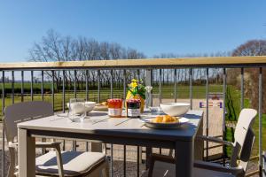 einen Tisch mit Speisen und Getränken auf dem Balkon in der Unterkunft The Hayloft in Chichester