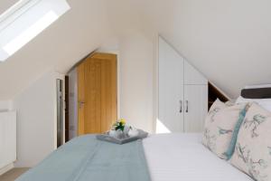 a bedroom with a large white bed with flowers on it at The Hayloft in Chichester