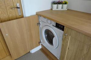 a washing machine in a kitchen with a counter at The Hayloft in Chichester