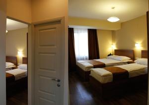 a hotel room with two beds and a door at 5th Floor Guest House Yerevan in Yerevan