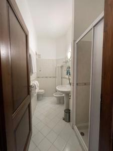 La salle de bains est pourvue de toilettes, d'un lavabo et d'une douche. dans l'établissement Hotel La Torre, à Castiglione dʼIntelvi
