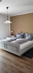 a large white bed in a room with wooden floors at JÄGERWINKL 2 in Rettenberg