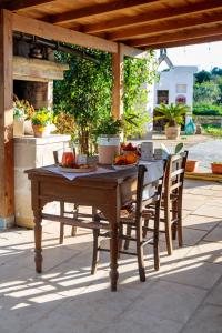 una mesa de madera y sillas sentadas bajo una pérgola en B&B Dimora Castello, en Galatone