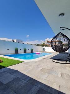 a view of a swimming pool with a swing at LuxVilla AURORA in Vodice