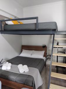 1 dormitorio con 2 literas y toallas blancas en ISMINI STUDIOS, en Menídion