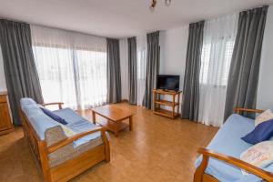 Sala de estar con 2 camas y TV en Apartments Niko en Santa Eulalia del Río