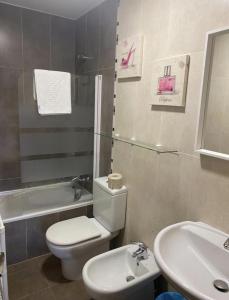 a bathroom with a white toilet and a sink at TORRES DE MONTENUÑO in Oviedo