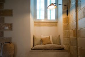 a window seat with a pillow in front of a window at Nonna Elvira in Specchia Gallone