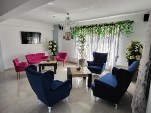 ママイア・ノルドにあるVila Zaraのリビングルーム(ピンクとブルーの椅子、テーブル付)