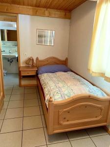 a bedroom with a wooden bed and a bathroom at OSTERIA RUBINO DA PAOLO in Acquarossa