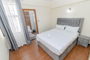 1 dormitorio con 1 cama grande y baño en New Luxury Apartment close to State House Nairobi, en Nairobi