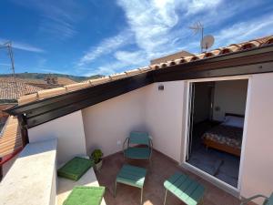 Un balcón con una cama y sillas en el techo en De LoCa Rooms, en Tropea