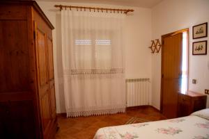 a bedroom with a white curtain and a window at Agriturismo Campo Contile in Chianciano Terme +15 photos