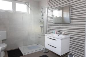 La salle de bains blanche est pourvue d'un lavabo et de toilettes. dans l'établissement Apartmani Murić - Ena, à Bjelovar