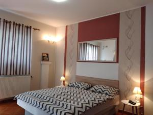 een slaapkamer met een groot bed en een spiegel bij Apartments Košević in Osijek