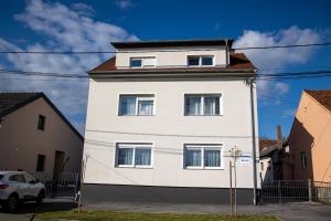 un edificio blanco con tres ventanas. en Apartmani Murić - Ena en Bjelovar