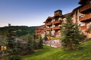 a view of a resort with trees in the foreground at Bachelor Gulch Village in Avon