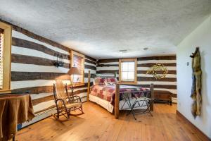 a bedroom with striped walls and a bed and a table at Rustic Wellsville Home - 5 Mi to Roundtop Mountain 