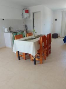 stół i krzesła w kuchni z białym stołem w obiekcie Departamentos el Peregrino w mieście San Luis