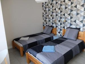 a bedroom with two beds and a tiled wall at Thermalines in Saint-Gervais-les-Bains