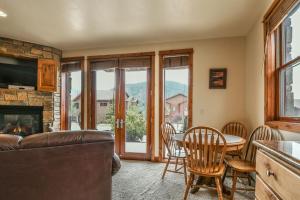 a living room with a table and chairs and a fireplace at Antlers Gulch 501 in Keystone