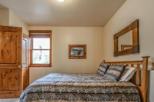 1 dormitorio con cama y espejo en Antlers Gulch 501, en Keystone