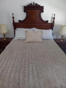 - un lit avec une tête de lit en bois et un oreiller dans l'établissement Chalet Chiclana, à Chiclana de la Frontera