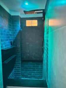 une salle de bain sombre avec des lumières bleues dans les escaliers dans l'établissement Sezimbra village flat, à Natal