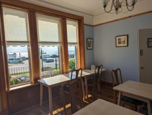 a dining room with tables and chairs and windows at The Cairns Leven Fife in Fife