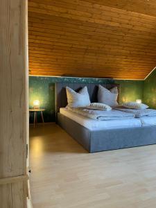 a bedroom with a large bed with a wooden ceiling at Ferienhaus Mone in Monschau