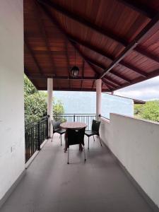 a patio with a table and chairs on a balcony at Pearl Villa,Mirissa in Kamburugamuwa