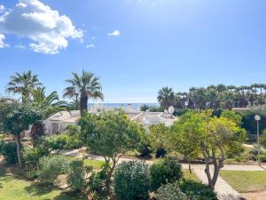 Elle offre une vue sur un jardin planté d'arbres et de buissons. dans l'établissement Lovely Apartment in Albufeira 2BD 250m Beach Ocean view and AC Wi-Fi Pool, à Albufeira