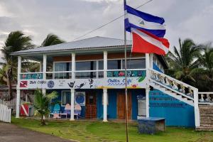 una casa azul con una bandera delante de ella en 'Crows Nest' Studio Apt., en Isla Grande del Maíz
