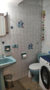 bagno con servizi igienici blu e lavandino di ELENI's House-Near the Old Railway Station a Nauplia