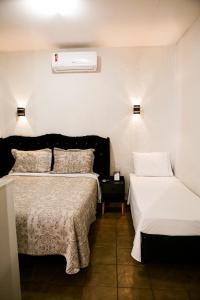a bedroom with two beds and a air conditioner on the wall at Hotel Recanto do Sossego in Uberlândia